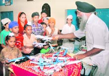 Children being handed out toy planes as gifts at Gurdwara Sant Baba Nihal Singh Ji Shaheedan at Talhan village, located on the on the outskirts of Jalandhar.