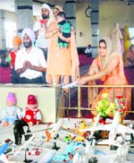 A woman devotee offers toy aeroplanes at the gurdwara.