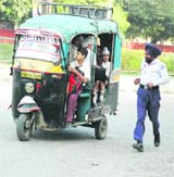 A traffic policeman chases an over-loaded auto-rickshaw in Jalandhar. 