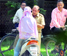 A guard asks a girl to reveal her face for security check on the PAU campus in Ludhiana