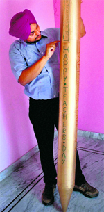 Limca Book record holder Amritpal shows a seven-feet-long pen on the eve of Teachers Day in Amritsar