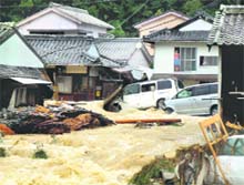 Overflowing water from a river floods a residential area in Nachikatsuura in central Japan on Sunday. 