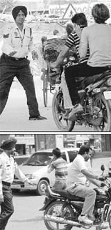 Traffic cops try to stop youths riding motorcycles without helmets in Zirakpur on Monday. 