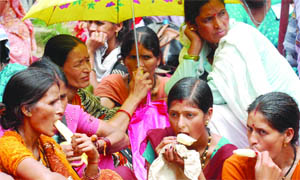 Activists of the All-India Central Council of Trade Unions (AICCTU) eat ice cream during a protest rally seeking regularisation of their jobs at Jantar Mantar in New Delhi 