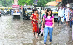 Residents wade through a flooded street near the main gate of the Railway Junction in Rohtak. 