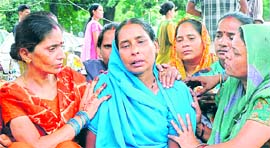 Relatives of Manju Devi, the victim, condole her mother at the Civil Hospital in Jalandhar on Monday.
