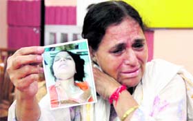 Sunita Sharma shows the photograph of her daughter, who committed suicide, in Jalandhar on Monday.