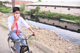 A school kid passes through the Budha Nullah near Kundan Puri, which has virtually turned into a garbage dump in Ludhiana