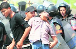 Cops detain a TV cameraman during clashes with anti-Mubarak demonstrators in Cairo. 