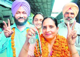 Ravinder Kaur Randhawa shows the medal at the Amritsar railway station on Tuesday