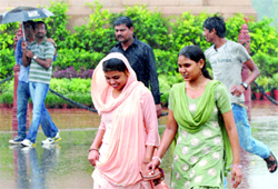People enjoy in the morning showers at India Gate in New Delhi on Tuesday