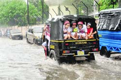 Students in an autorickshaw enjoy themselves after a downpour in Dehradun on Tuesday. 