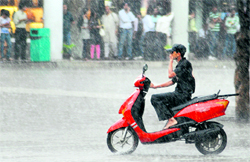A bike rider caught in a downpour at the Sector-17 piazza in Chandigarh on Wednesday