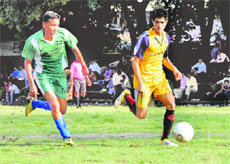 Two players chase the ball in the Lala Nemi Dass Memorial District Football League played on the Pavilion Ground in Dehradun on Wednesday.