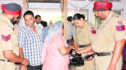 Punjab police personnel conduct security checks using metal detectors at the judicial courts complex in Jalandhar