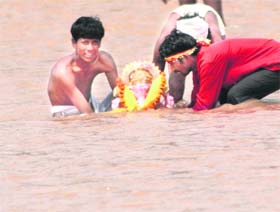 Devotees immerse an idol of Lord Ganesha in the Tawi in Jammu on Wednesday.