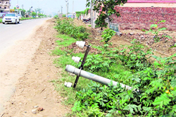 A telephone pole lies on the side of the Airport road in Amritsar