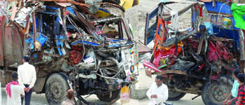 Two loaded trucks reduced to a mangled heap following a collision, in which one person died, in East Delhi