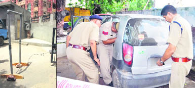  A door frame metal detector at the entrance to the judicial complex at Rohtak; and (right) cops inspect a car found abandoned in Faridabad on Thursday. 