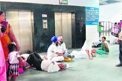Patients wait for wheelchairs as elevators lie dysfunctional at the Civil Hospital in Amritsar. 