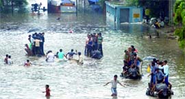 People use buffalo carts to cross a flooded road near Shahdara Metro station.