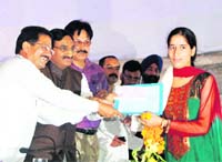 Chief Minister Ramesh Pokhriyal Nishank presents an award to a member of a van panchayat at a function held in Dehradun on Friday. 