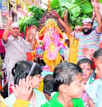 Devotees take part in a shobha yatra during the ongoing Ganesh festival in Karnal on Friday.