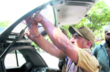 A policeman removes a dark film from the windowpane of a car in Jammu on Friday