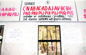 Hand-written notices regarding technical fault in the computer system and absence of the employee concerned at the registration counter pasted on the wall of the DTO office in Jalandhar. 