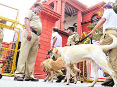 Security personnel with sniffer dogs arrive for checking at the Karnataka High Court in Bangalore on Friday. 