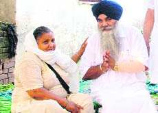 Kewal Singh Badal talks to a woman in Ladian Kalan village near Ludhiana. 