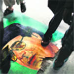 Libyans step on a poster of Muammar Gaddafi used as a doormat at Tripolis main hospital