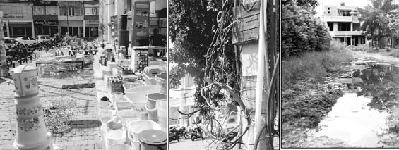 Shopkeepers have encroached upon land in front of their shops; and (centre) loose electricity wires hang from a pole in Sector 2. A damaged road at Mansa Devi Complex.