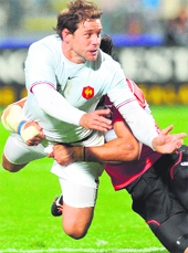 France's Cedric Heymans is tackled by Japan's Ryukoliniashi Holani in the 2011 Rugby World Cup Pool-A match in Auckland on Saturday. France beat Japan 47-21