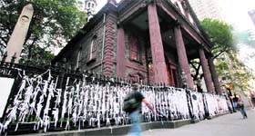 A man walks past St. Pauls Chapel where people have tied memorial ribbons along the fence to remember victims of the 9/11 attacks in New York on Saturday.