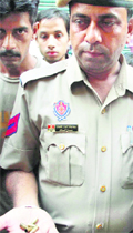 A police official shows bullet shells after the shooting incident in Jalandhar on Sunday