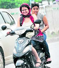 Girls try to save themselves from sudden showers in Ludhiana on Sunday.