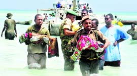 Tanzanian policemen with bodies of children at the sea in Zanzibar, Tanzania.