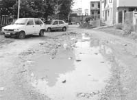 Water accumulated in a damaged road at Phase IX