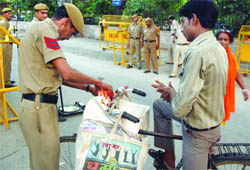 Delhi police personnel check the bag of a cyclist near the Delhi High Court in New Delhi