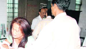 The wife of the slain Deputy Jailer weeps near his body at a Roorkee hospital on Monday.