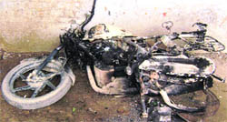 A motorcycle burnt by miscreants on the Jandali road at Ahmedgarh . 