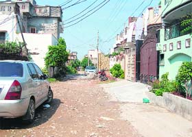 A view of a road of an ilegal colony without a concrete road and sewerage but a number of plush new houses have come up in them