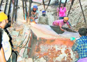 An attempt being made to dismantle the paapar-drying machine which posed a hindrance in locating the persons trapped in the debris of a roof collapse