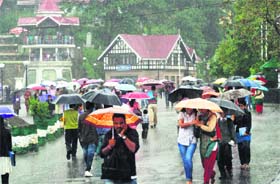 Tourists enjoy a rainy spell at The Mall in Shimla