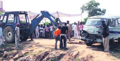 Villagers remove the damaged school van from the railway track at Mouwal village in Nakodar
