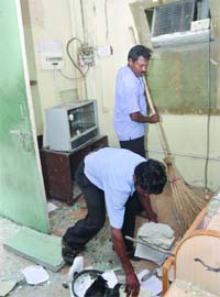 Workers of the Delhi High Court clean the reception area that was reopened to the public on Wednesday, a week after the bomb blast
