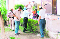 Officials check plants with a metal detector at Green Land School following a hoax bomb call in Ludhiana on Wednesday