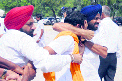 Activists of the ruling SAD whisk away a protester from the CMs election rally at Gidderbaha