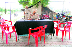 A police official works outside the Kabir Park Police Post, running from a tent